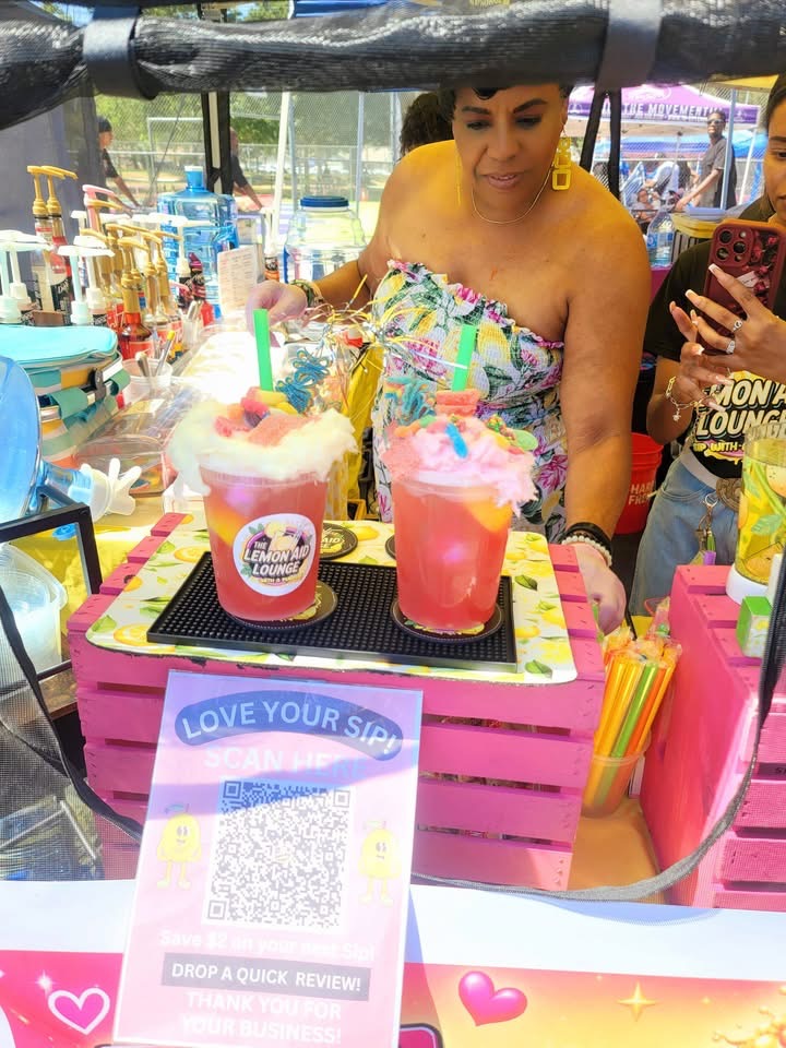 The Lemon Aid Diva serving colorful lemonades at a community event